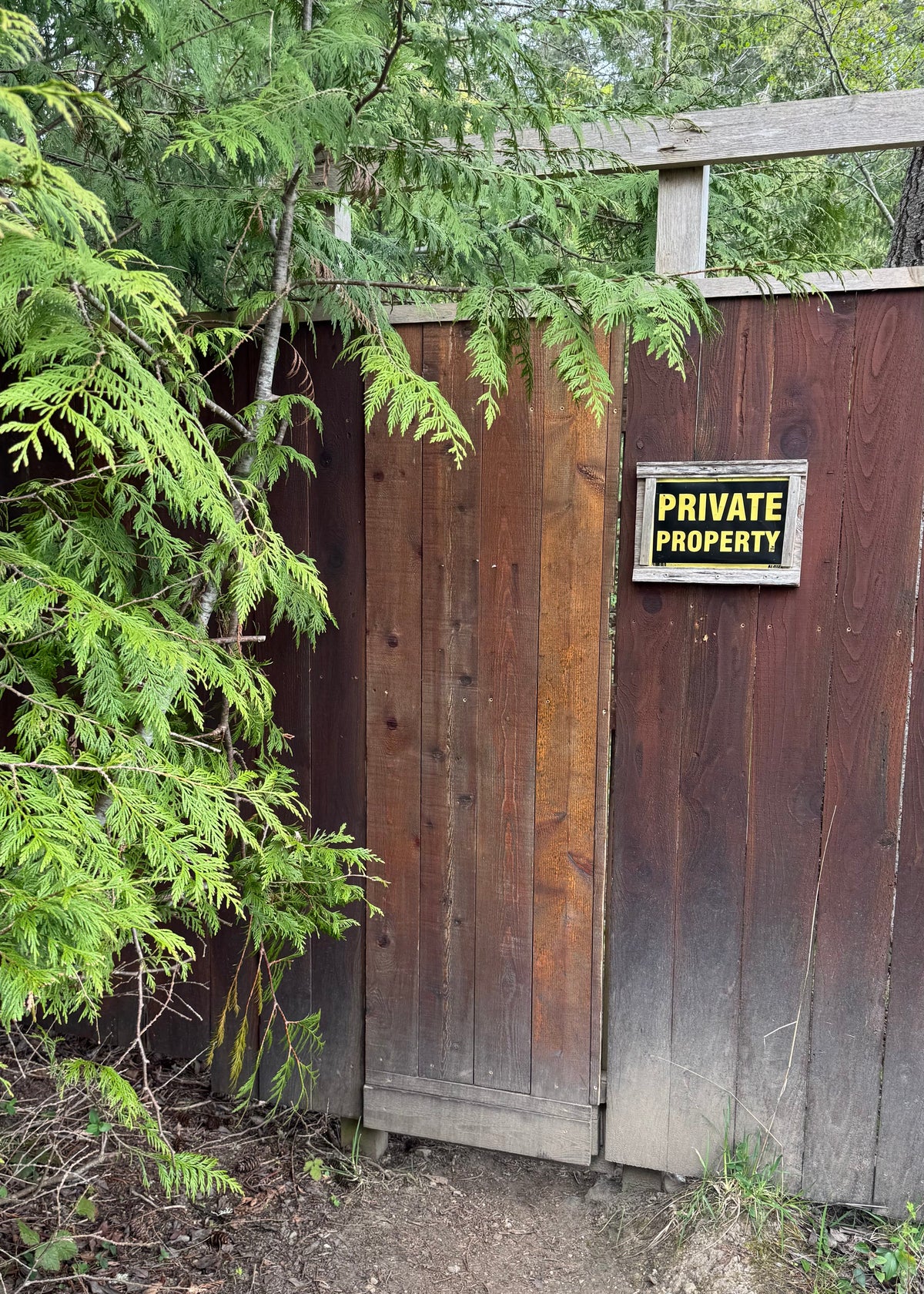 Wooden gate with a 'Private Property' sign in a forest setting